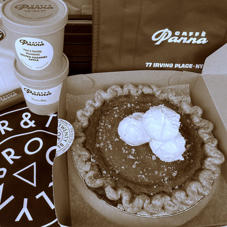 Pumpkin pie with whipped cream in a box, next to Panna ice cream containers and a branded bag.