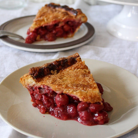 Slices of sour cherry pie on plates with fork